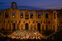 Avondconcert met orkest in een Grieks amfitheater onder zachte verlichting en volle tribunes