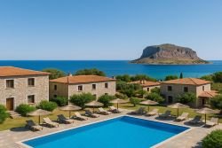 Luxe vakantieverblijf Douka Seafront Residences in Monemvasia met zwembad, zonneterras en uitzicht op de zee en rots van Monemvasia aan de Peloponnesos-kust.