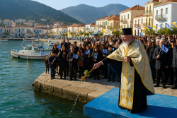 Orthodoxe priester gooit een kruis in het water bij een Griekse haven onder een heldere hemel