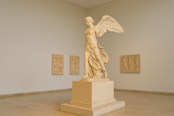 Breedbeeldfoto van het marmeren standbeeld van Nike van Paionios in een museumzaal, met bas-reliëfs aan de muren en een rustige, klassieke setting.