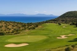 Uitzicht op een golfbaan aan zee in Griekenland met olijfbomen en groene fairways